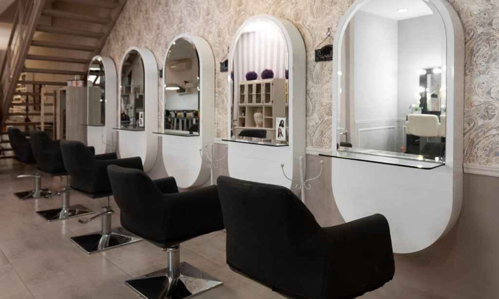 Interior of a bright beauty salon space for lease showing styling chairs and wash stations