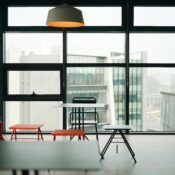 Modern ADA-compliant business space for lease featuring large windows, minimalist furniture, and a bright, accessible interior with city views.