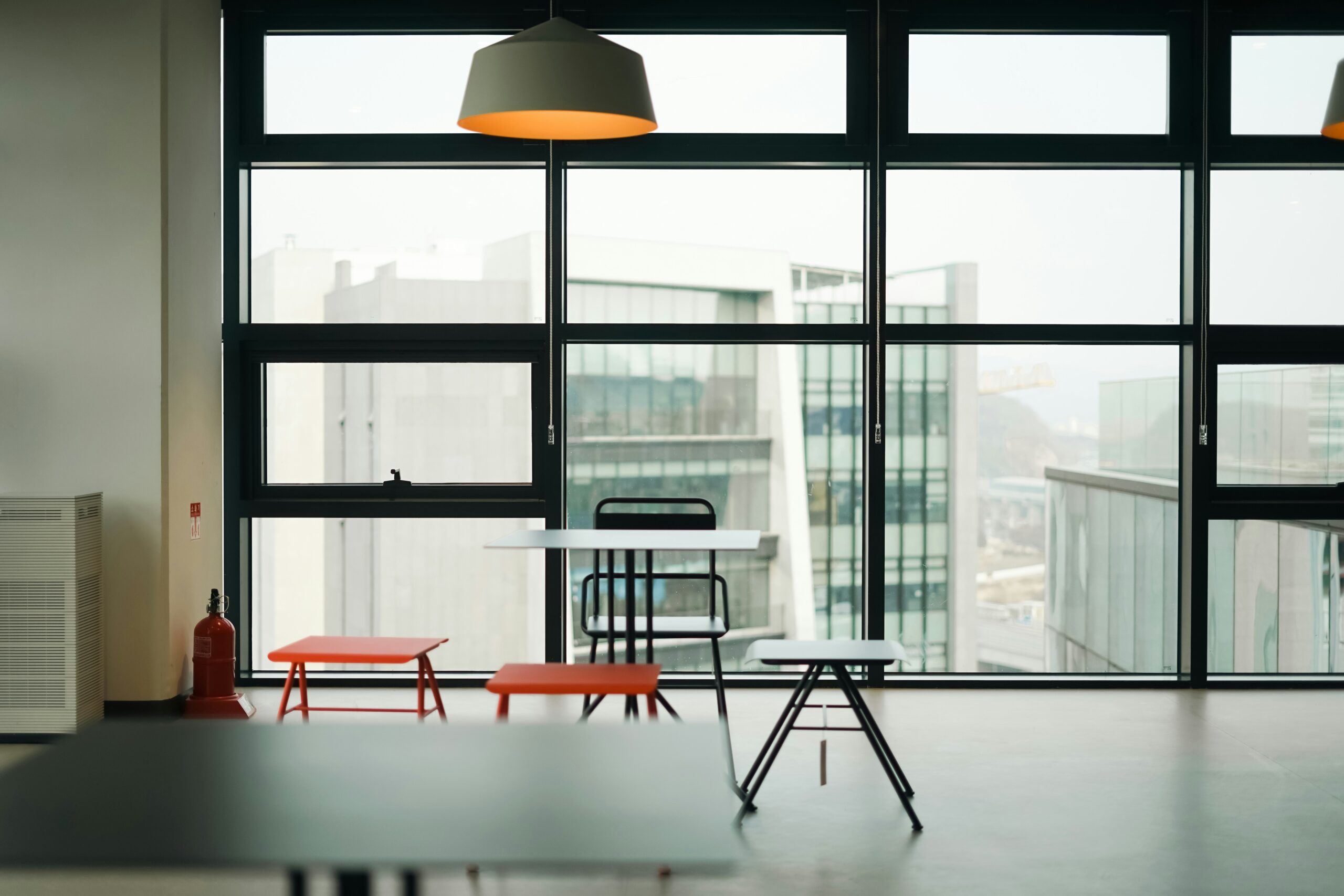Modern ADA-compliant business space for lease featuring large windows, minimalist furniture, and a bright, accessible interior with city views.