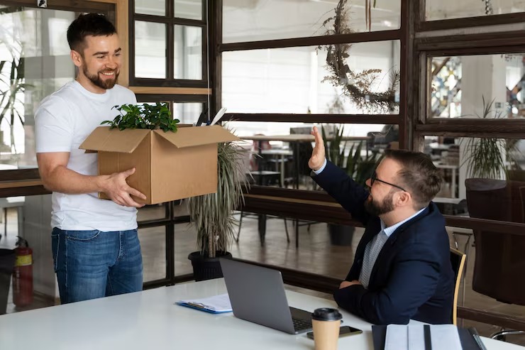 Professional resigning from office and saying goodbye to boss with a box of personal belongings.