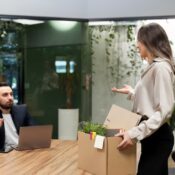 Woman quitting her job and carrying her belongings in a box.